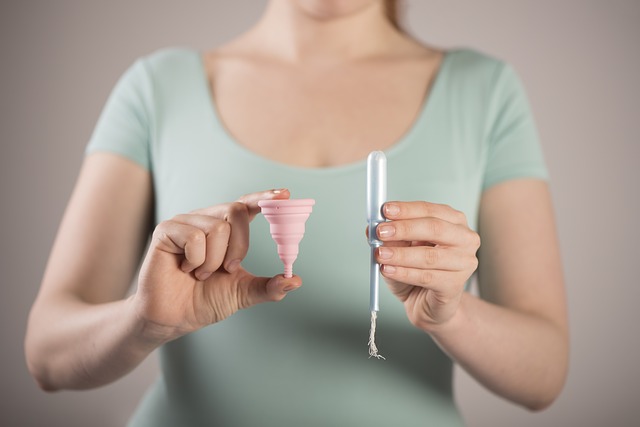 žena s menstruačním kalíškem a tamponem